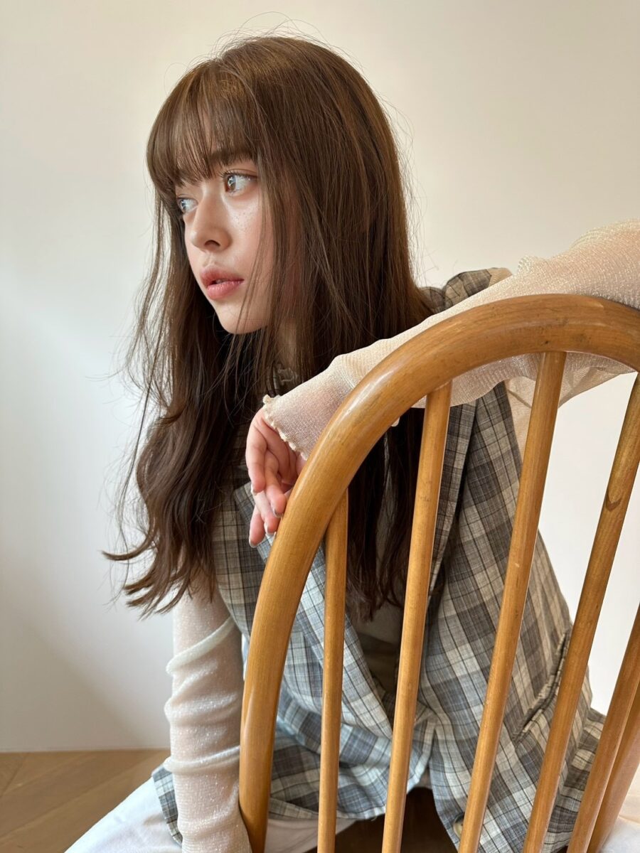 横顔から覗く自然なウェーブが揺れるロングヘアのアップ