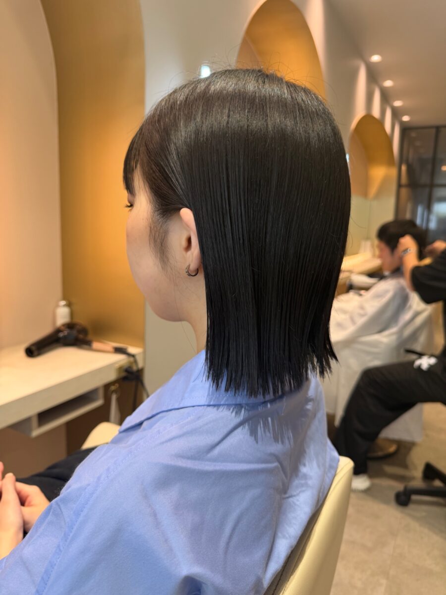 艶やかな黒髪の内側すっきり外ハネミディアムを後ろから捉えたヘアスタイル